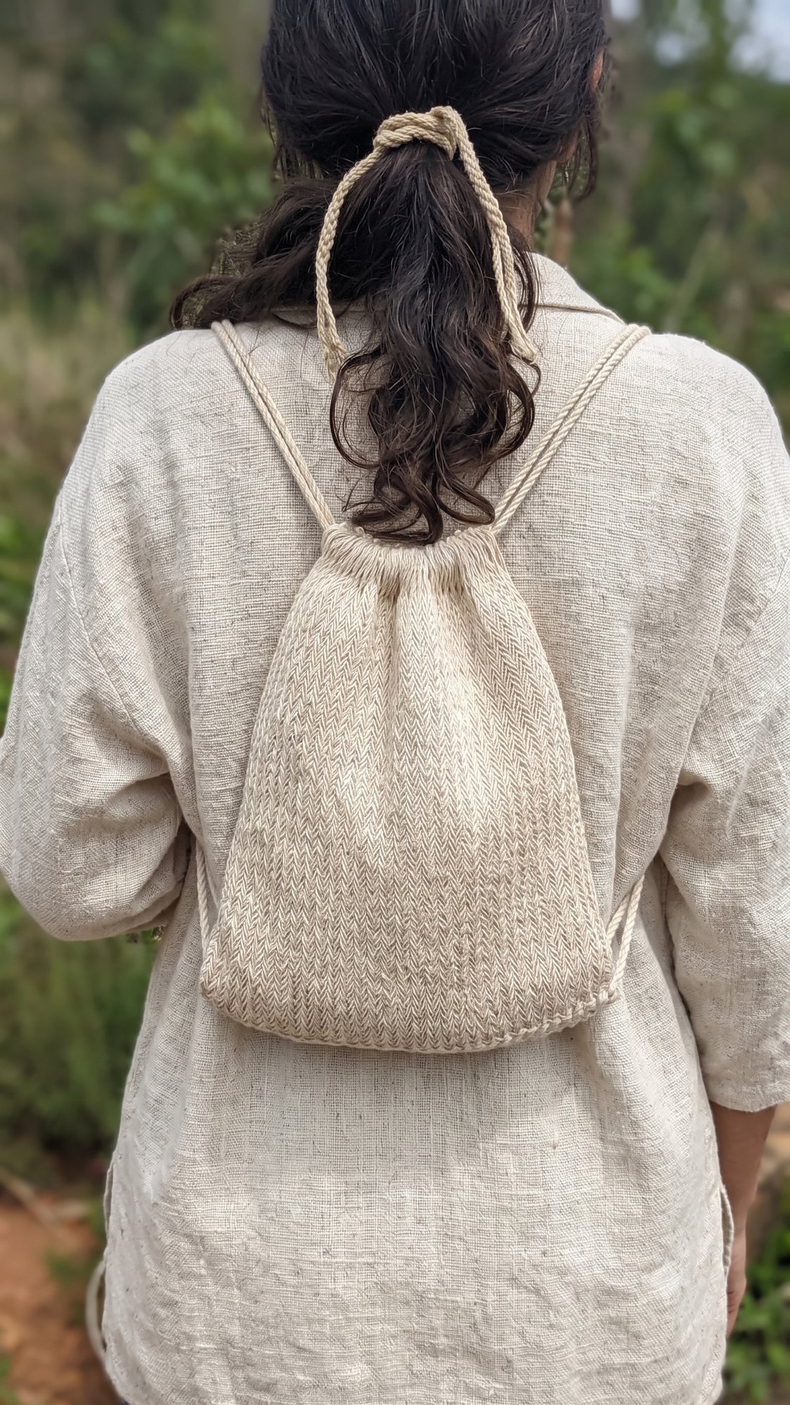 Mochila de fique llevada a la espalda, tejida en espiga, en el campo