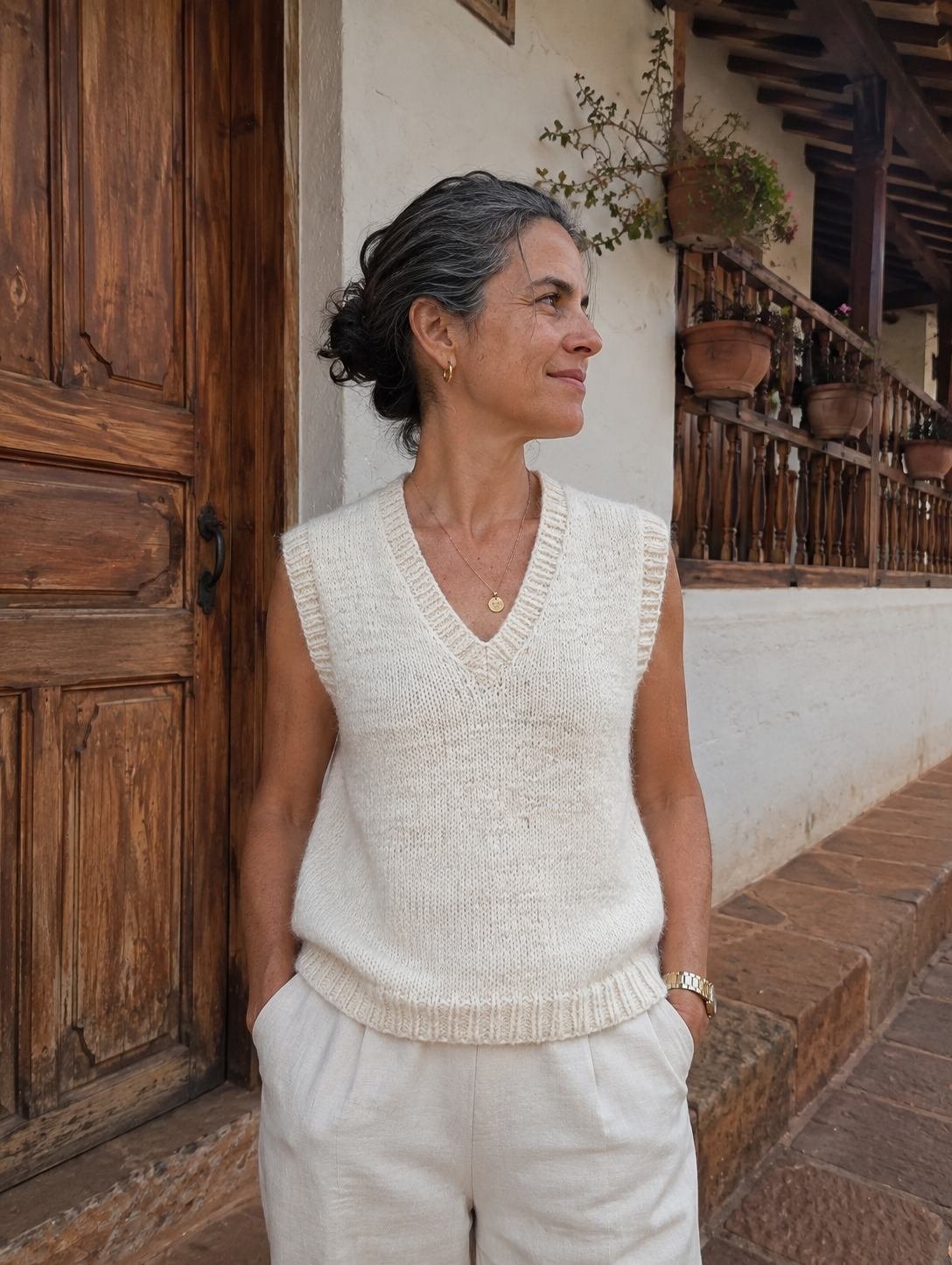 Chaleco de lana cruda tejido a mano, puesto por una modelo en una calle colonial